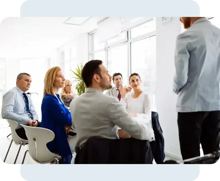 Medewerkers volgen een presentatie