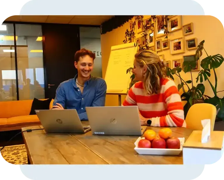 Twee collega?s werken samen op een laptop